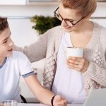 Positive mother and boy resting in the kitchen